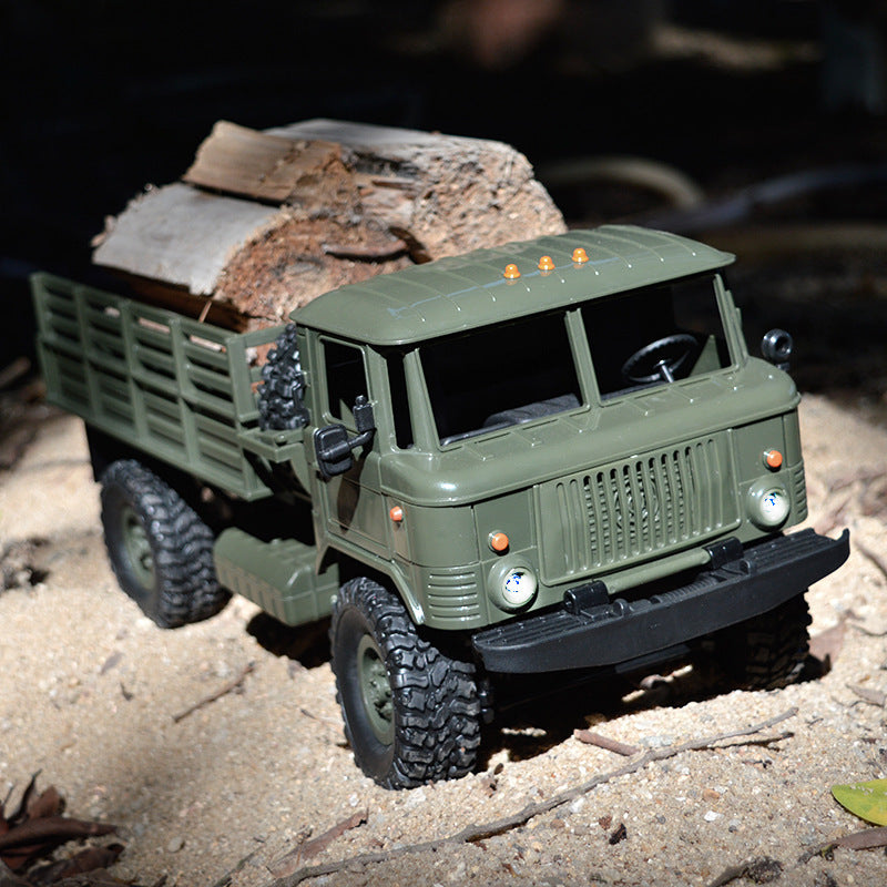 Green military RC truck hauling firewood on sandy terrain