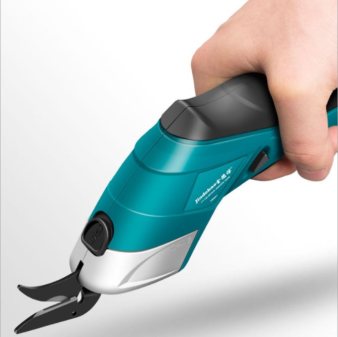 Close-up of a hand holding teal and black multifunctional electric scissors, featuring an ergonomic grip and sharp dual blades for precise cutting on various materials.