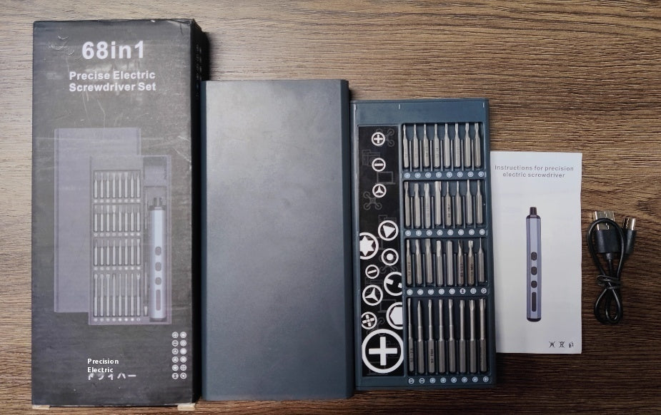 68-in-1 precise electric screwdriver set displayed on a wooden surface, including the product box, open case with multiple screwdriver bits, electric screwdriver handle, user manual, and a USB charging cable.
