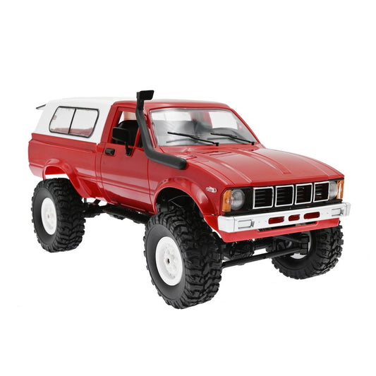 Red RC vintage pickup truck with white camper shell, rugged off-road tires, and snorkel intake pipe, front-side view
