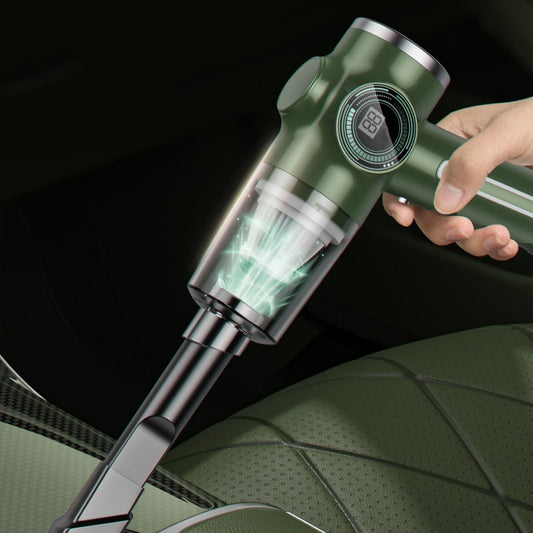 A handheld vacuum cleaner in green color being used on a car seat, showing the vacuum head inserted into a crevice tool.