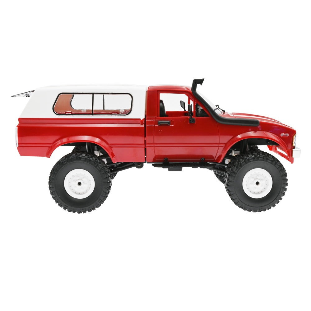 Side profile of red off-road RC truck showing classic pickup body style and lifted suspension system