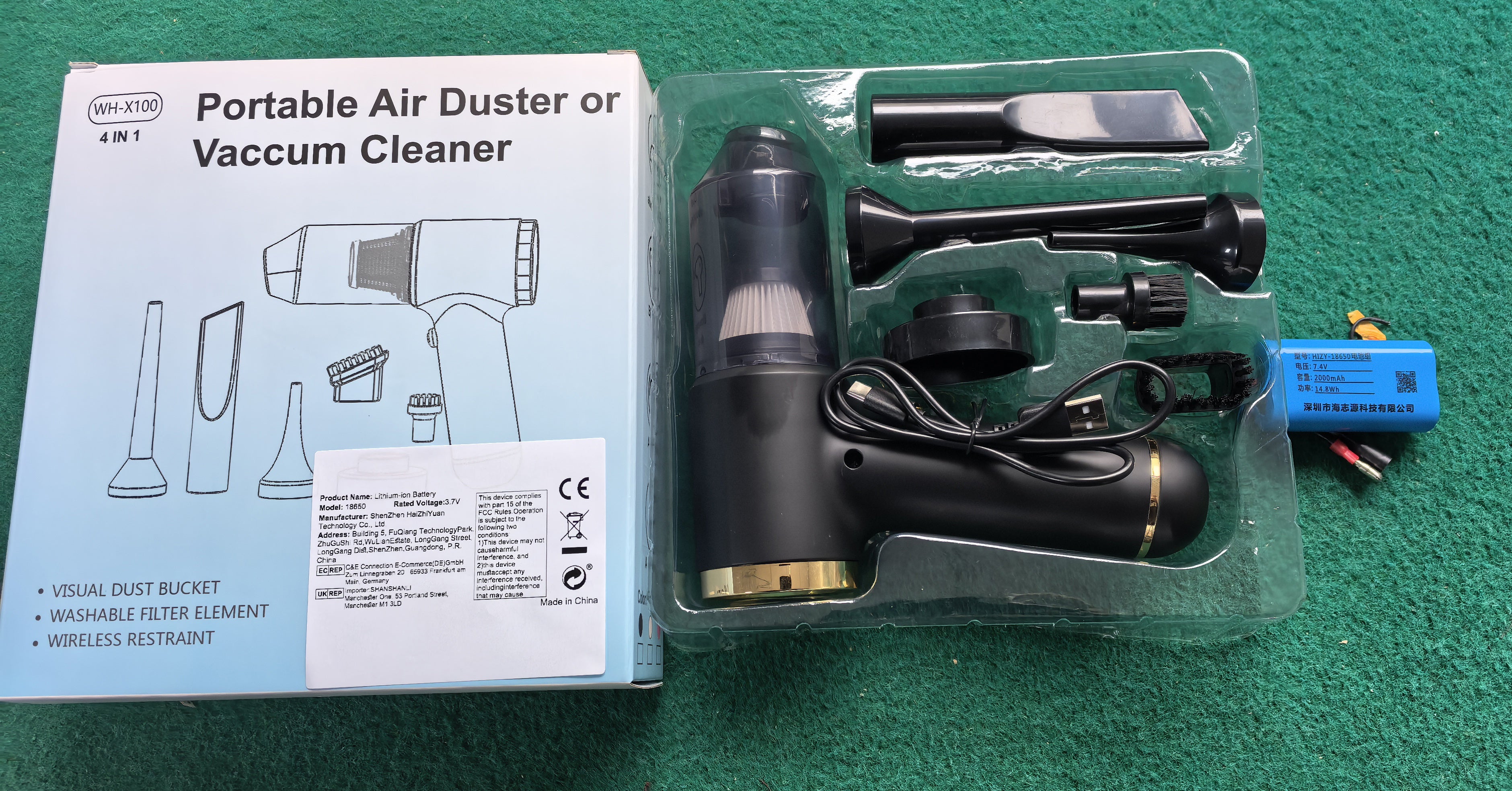 Portable air duster or vacuum cleaner with packaging on a green surface