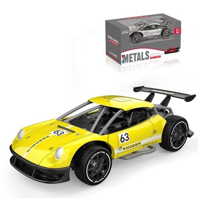 Yellow toy race car with black wheels and '63' on a white background, next to its packaging.