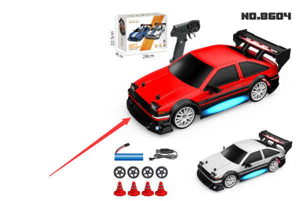 Red toy car with remote control, accessories, and packaging on a white background