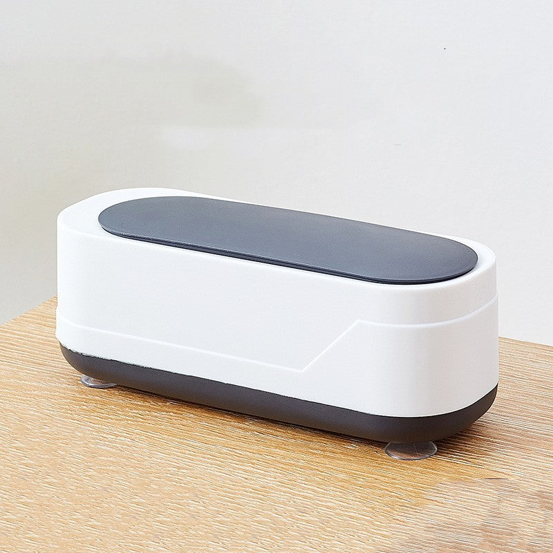 Sleek white and black compact storage case with suction feet, placed on a wooden surface—ideal for organizing kids’ utensils or travel accessories.