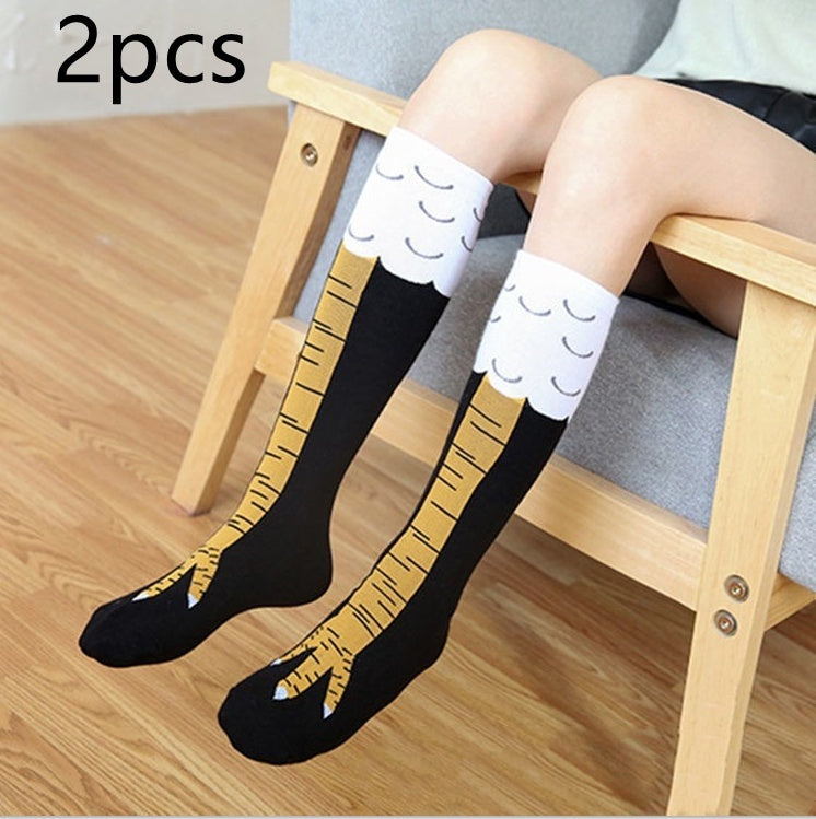 Person sitting on a wooden chair wearing a pair of novelty knee-high socks designed to resemble bird legs with yellow talons and white feather tops; text 