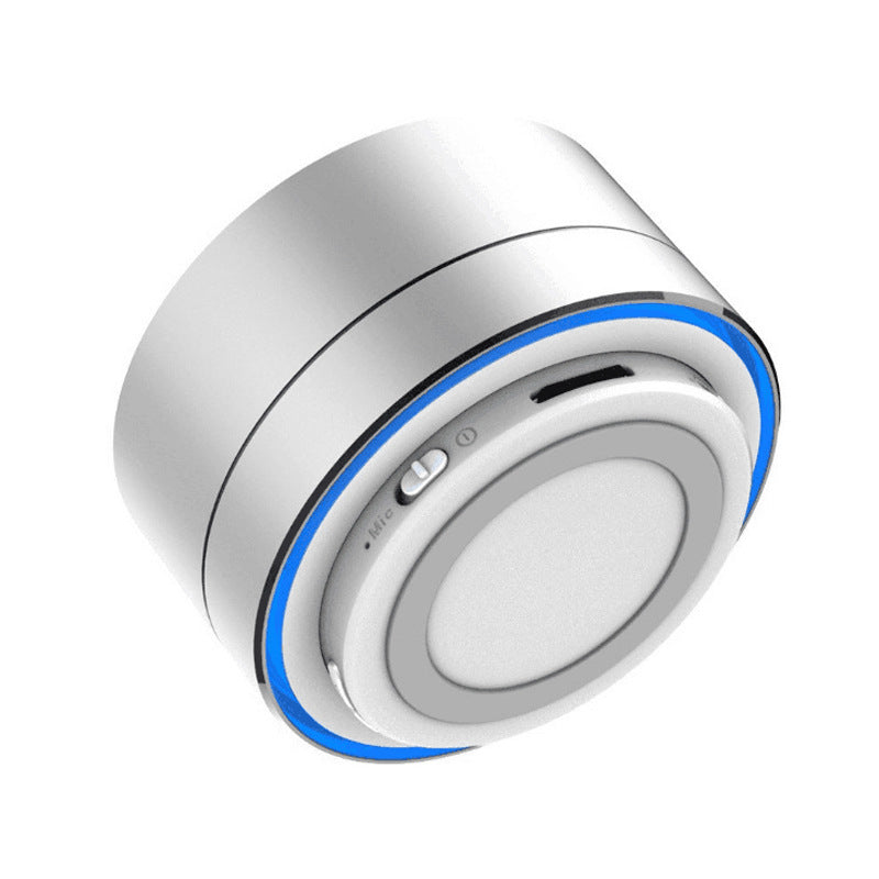 Compact silver Bluetooth speaker with bottom-mounted controls, microSD card slot, and blue LED accent ring for modern visual appeal.