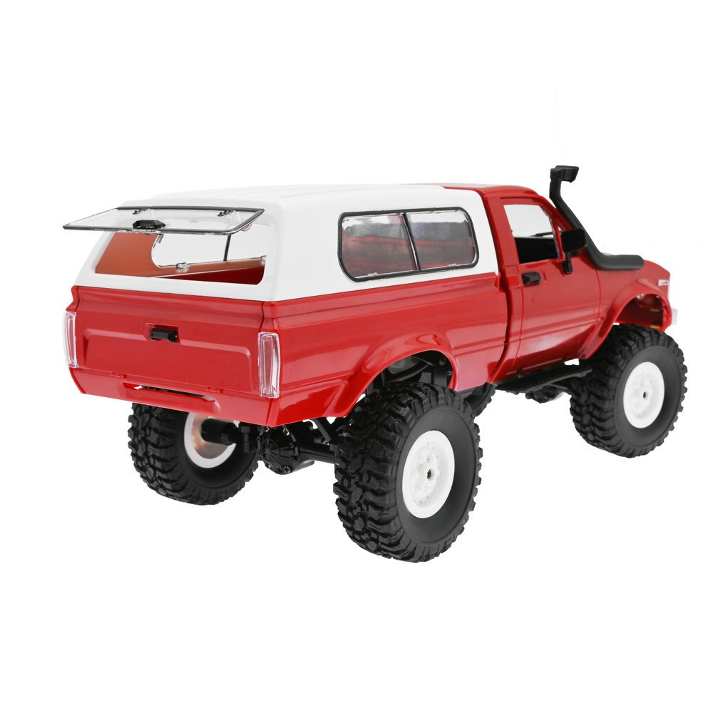 Rear view of red RC truck with raised suspension and opening rear window on white camper shell