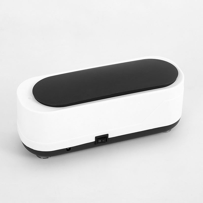 Compact white and black ultrasonic cleaning device with a sleek lid, shown against a plain background.