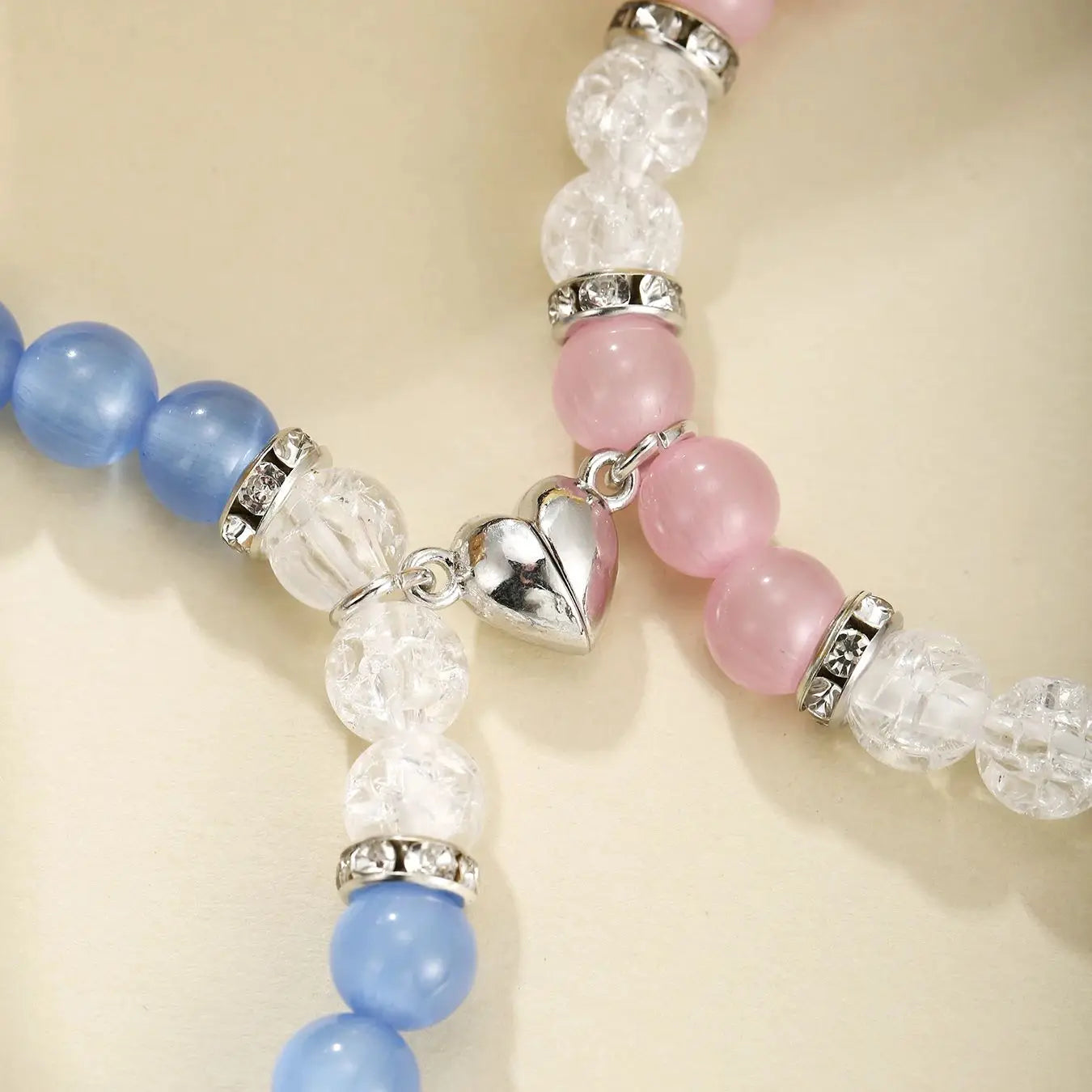 Close-up of a bracelet with blue, pink, and white beads on a beige background