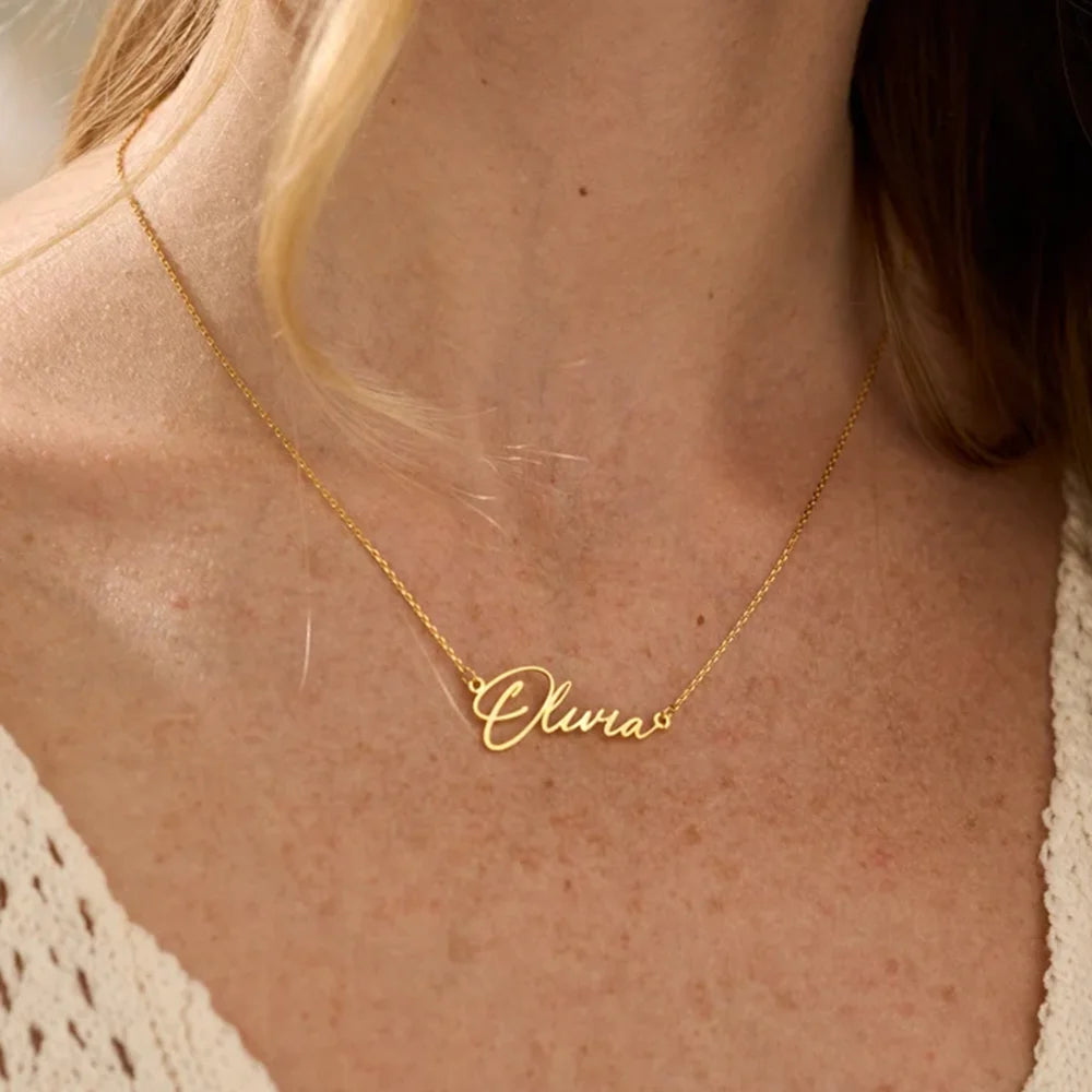 Gold necklace with 'Olivia' pendant on a person's neck