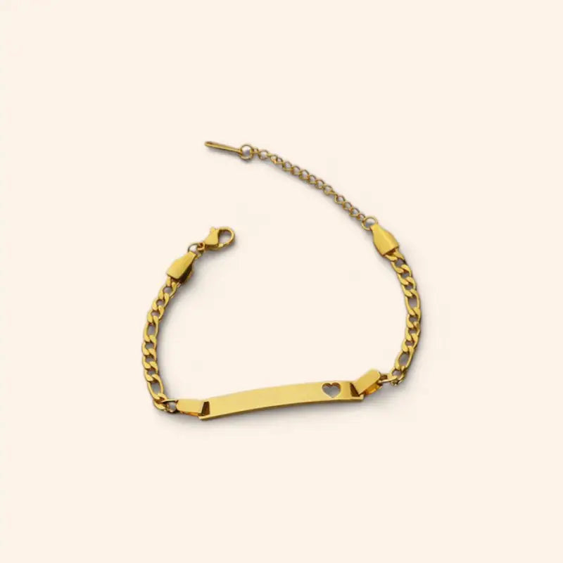 Gold bracelet with a heart charm on a beige background