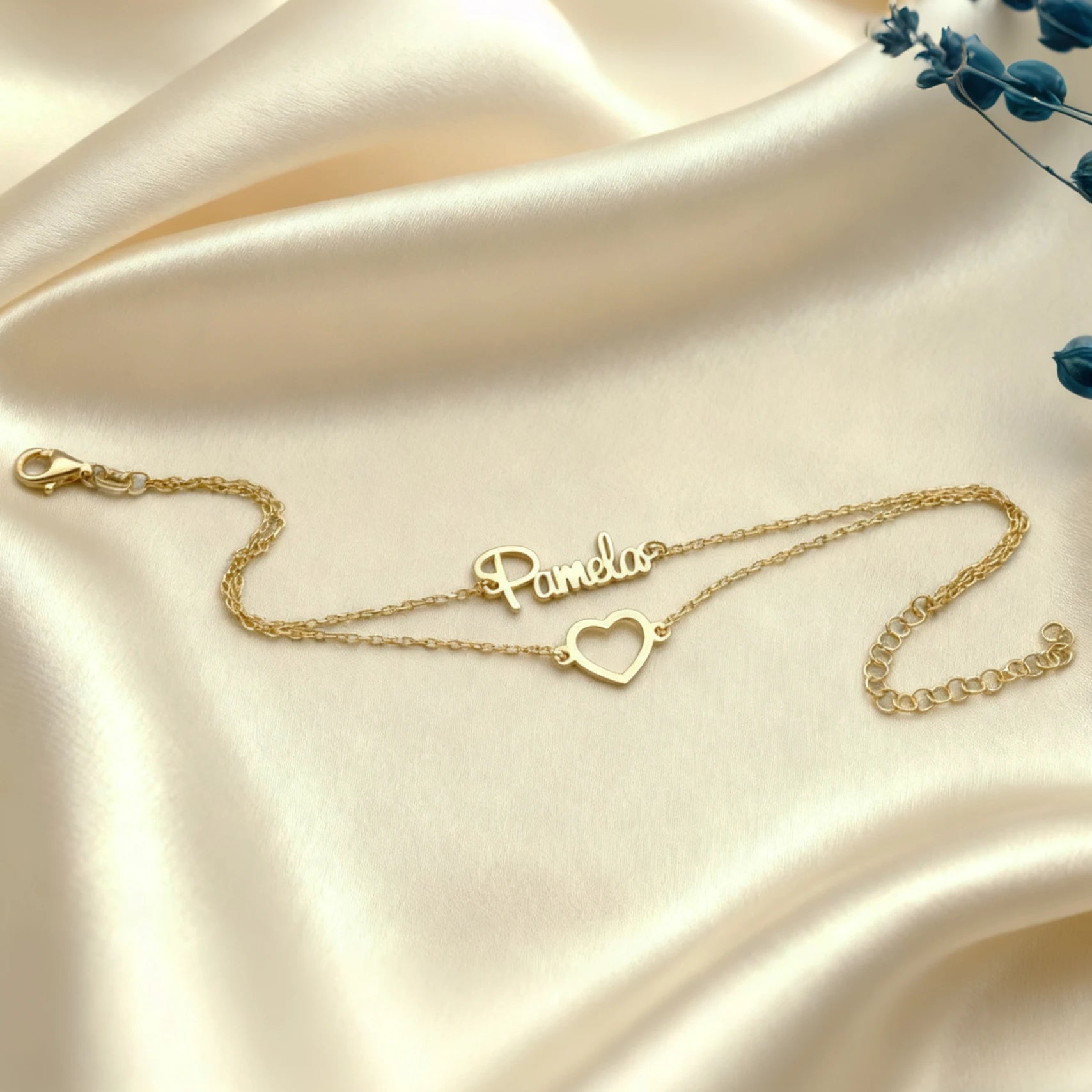 Gold necklace with 'Pamela' on a satin surface