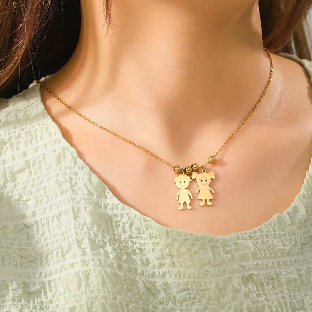 Gold necklace with two bear pendants on a person wearing a light green top.
