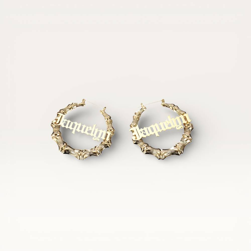 Gold hoop earrings with engraved names on a light gray background