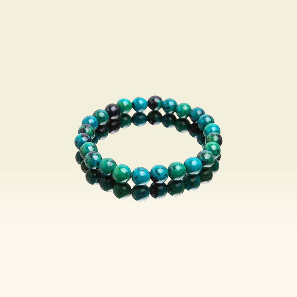 Green and black beaded bracelet on a beige background