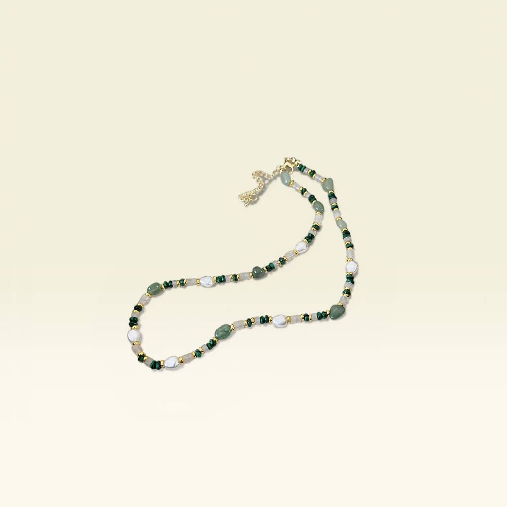 Beaded necklace with green and white stones on a beige background