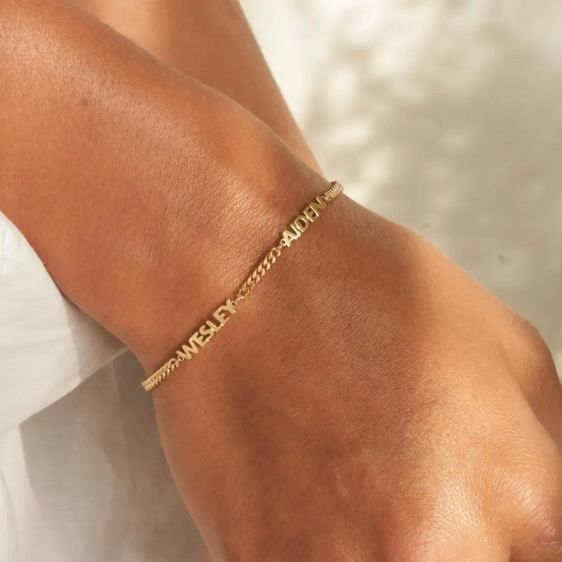 Gold bracelet on a wrist with a blurred background