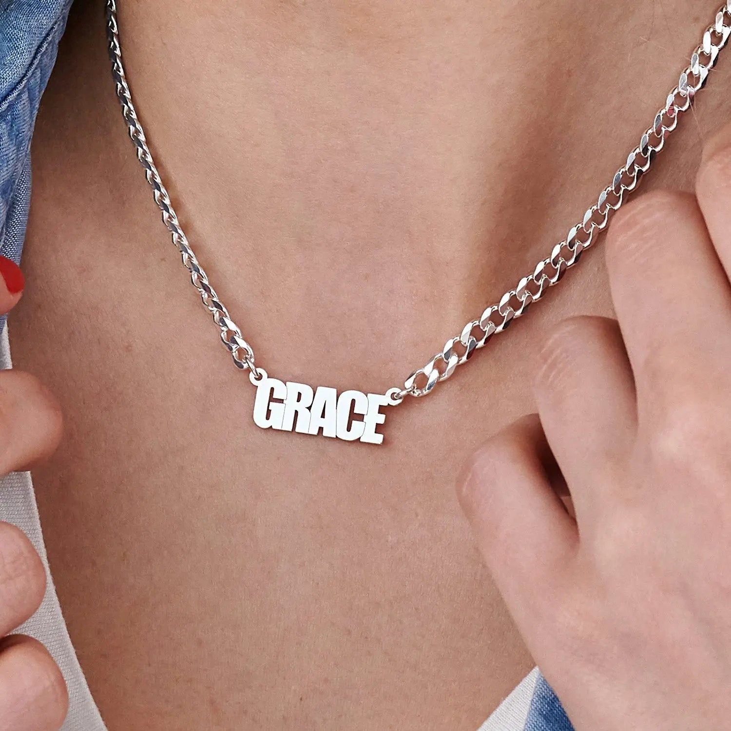 Silver 'GRACE' necklace on a person's neck with a close-up view.