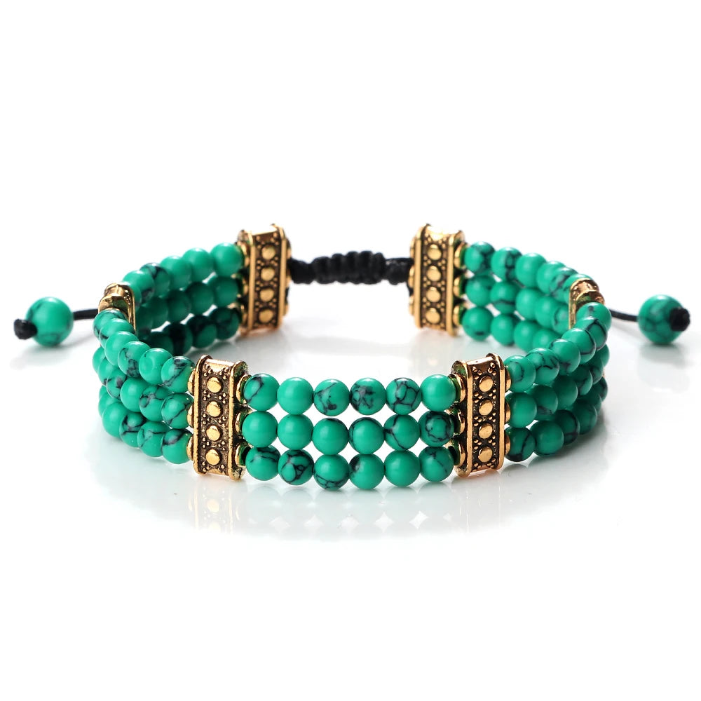 Green beaded bracelet with gold accents on a white background