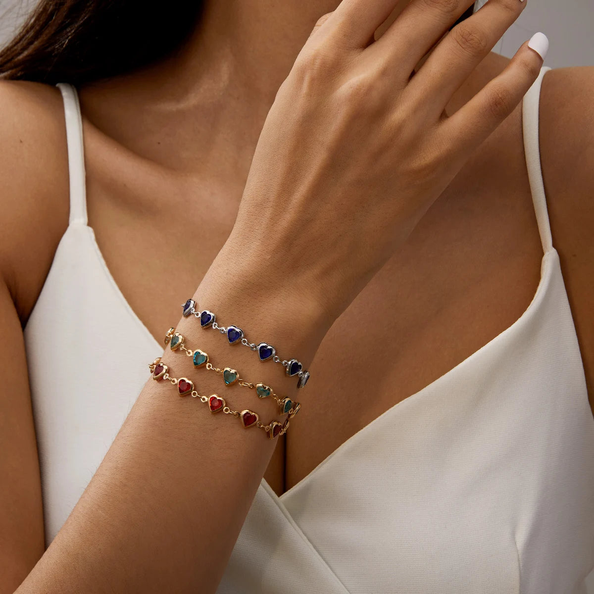 Close-up of a person wearing colorful beaded bracelets on a neutral background
