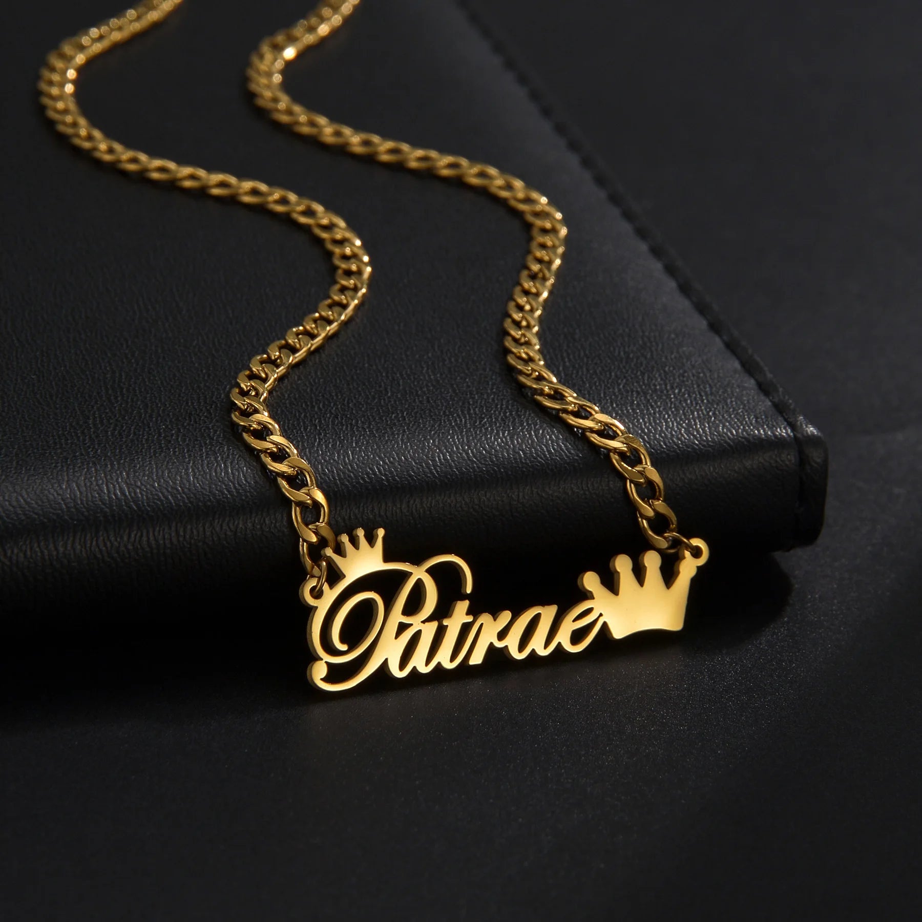Gold necklace with 'Patrae' pendant on a black background