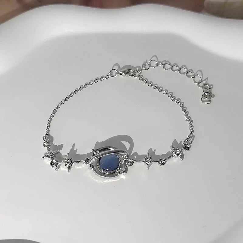 Silver bracelet with a blue stone on a white mannequin hand.