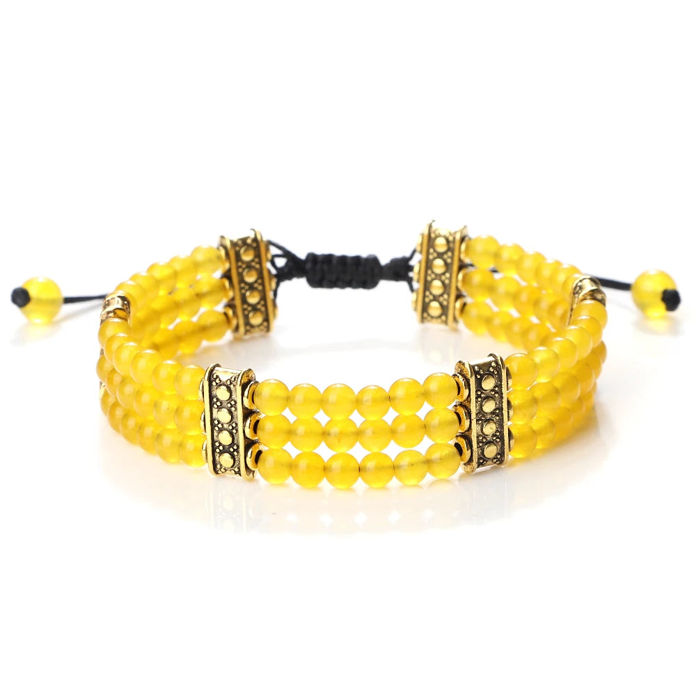 Yellow beaded bracelet with gold accents on a white background