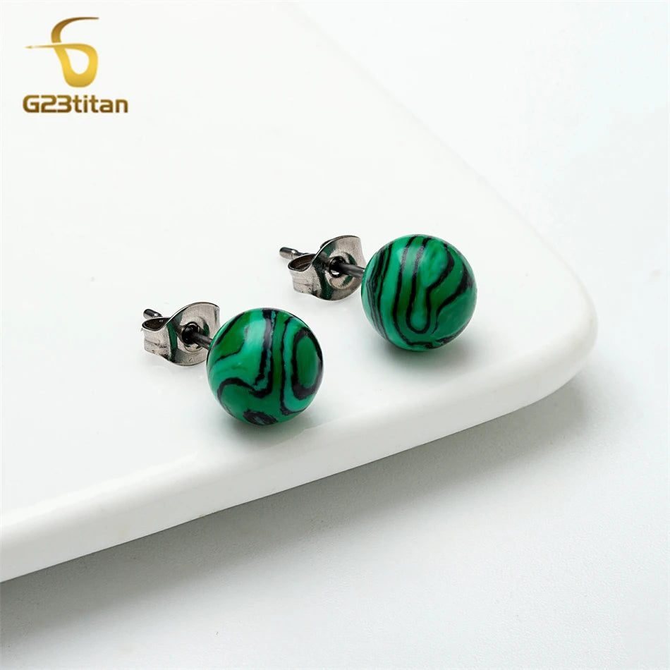 Green marbled earrings on a white surface with G23Titan logo.