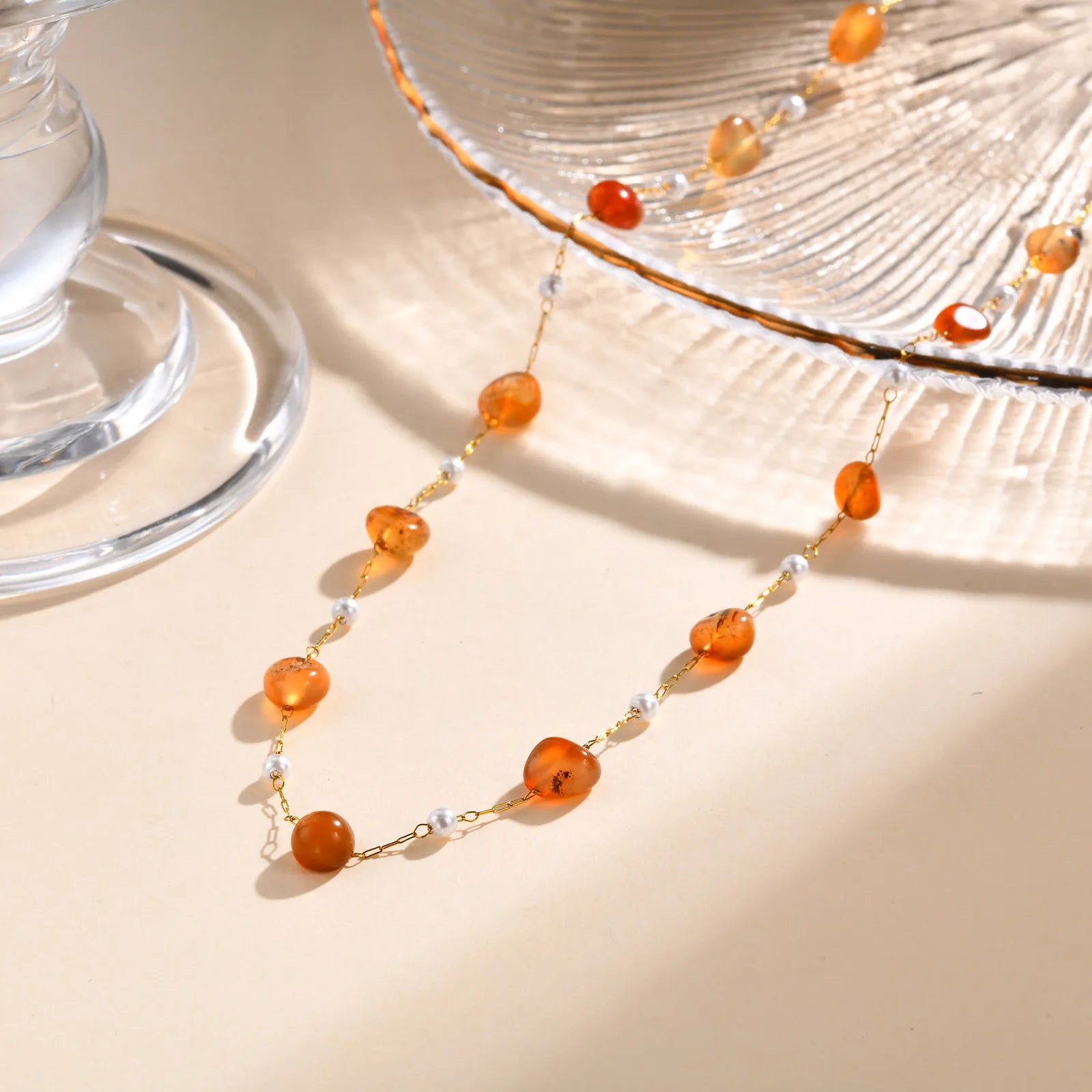 Necklace with orange beads on a beige surface