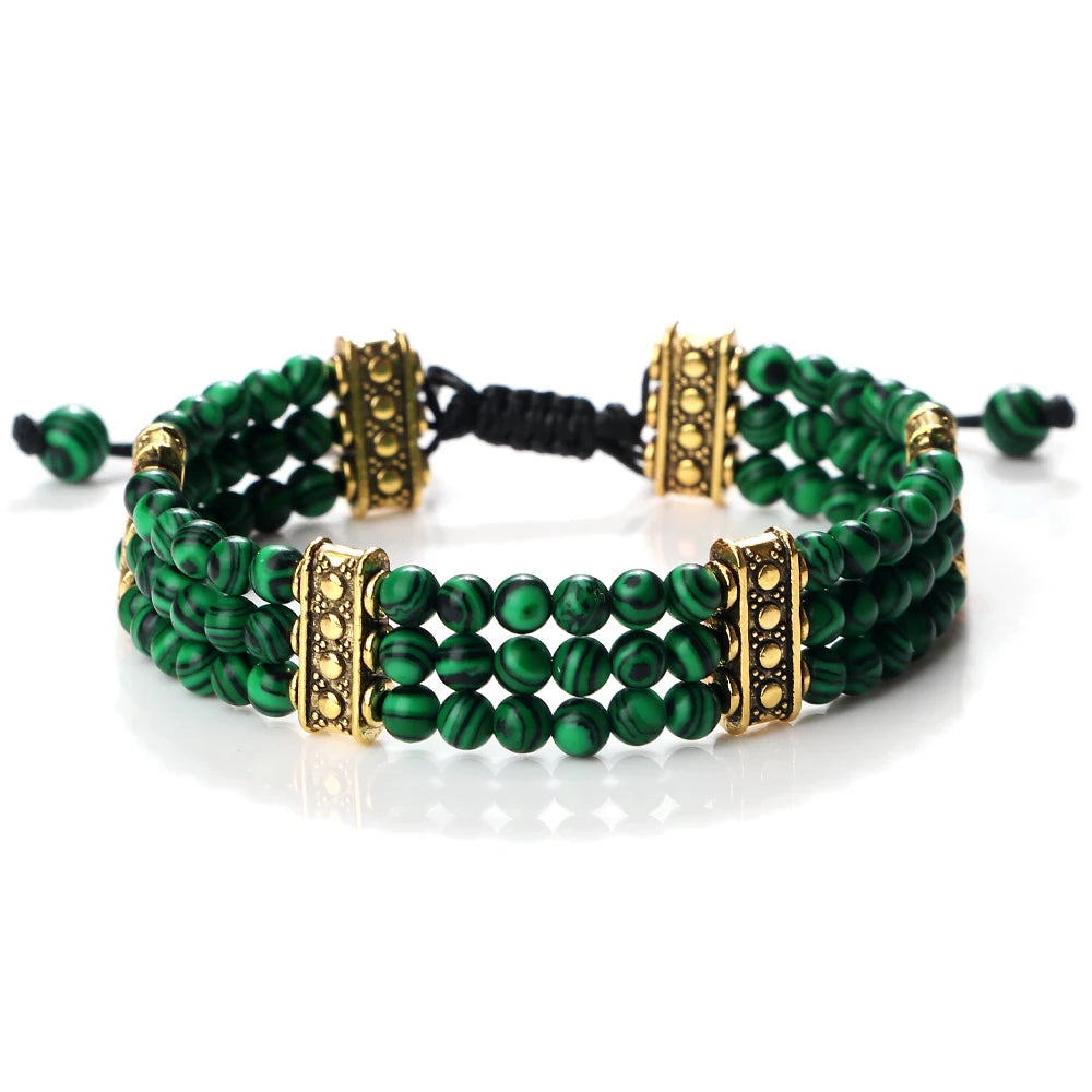 Green beaded bracelet with gold accents on a white background