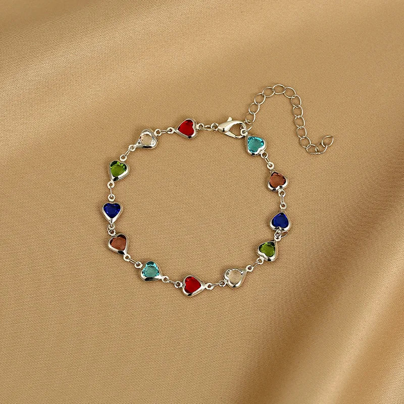 Bracelet with colorful heart-shaped charms on a beige fabric background