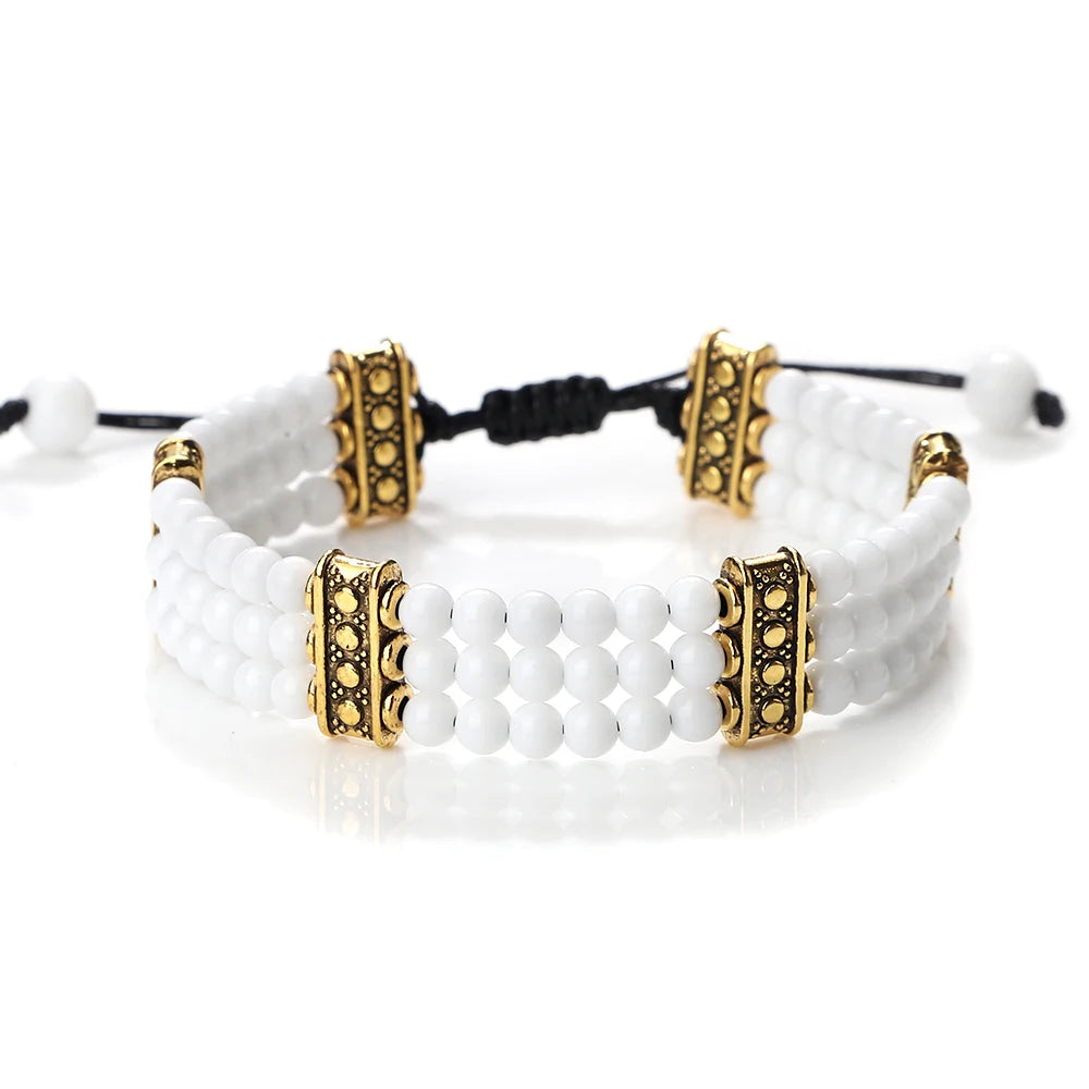 White beaded bracelet with gold accents on a white background