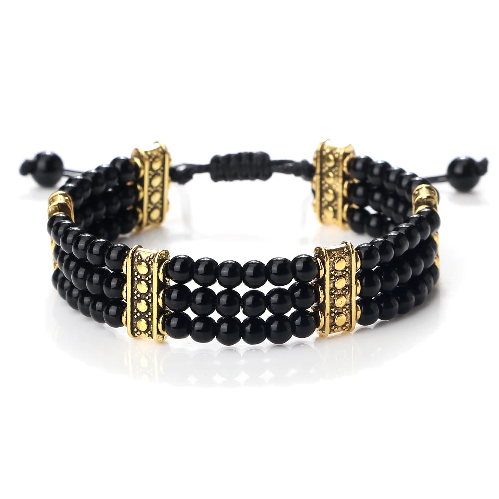 Black beaded bracelet with gold accents on a white background