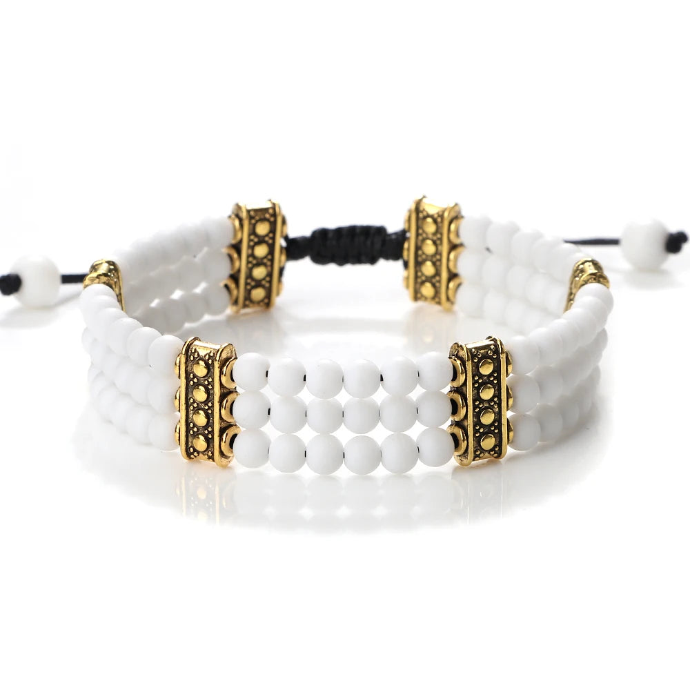 White beaded bracelet with gold accents on a white background