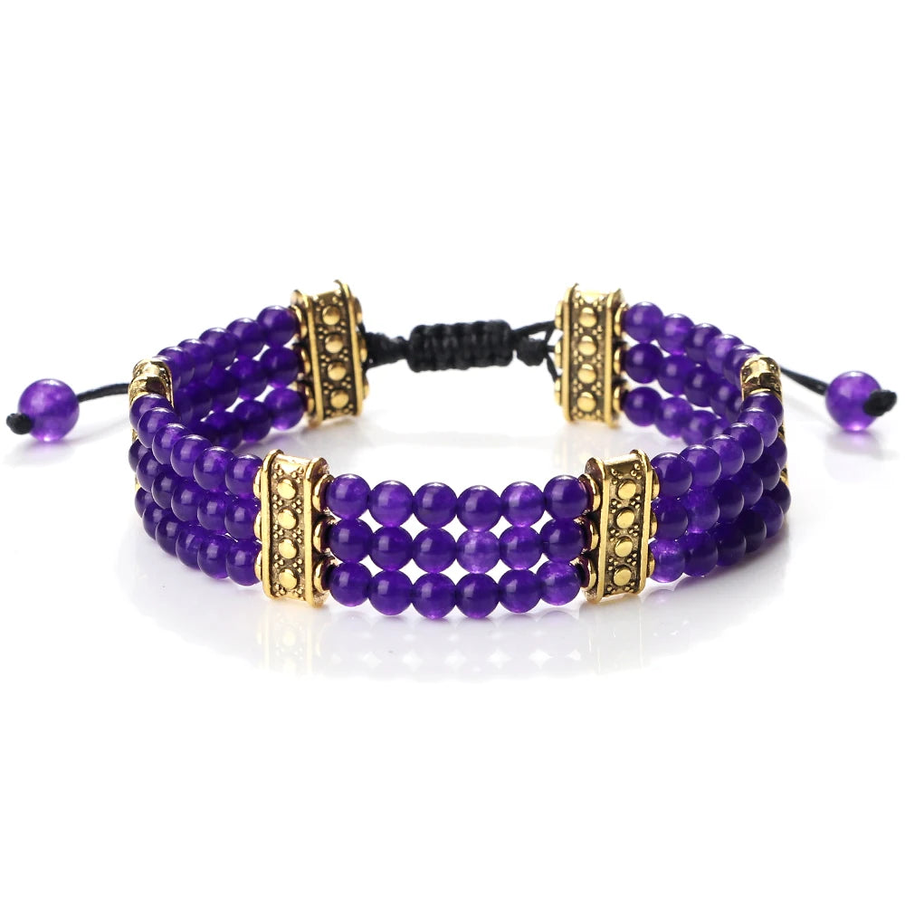 Purple beaded bracelet with gold accents on a white background