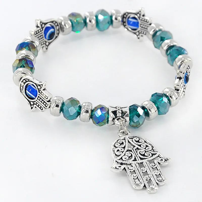 Bracelet with blue beads and silver Hamsa hand charms on a white background