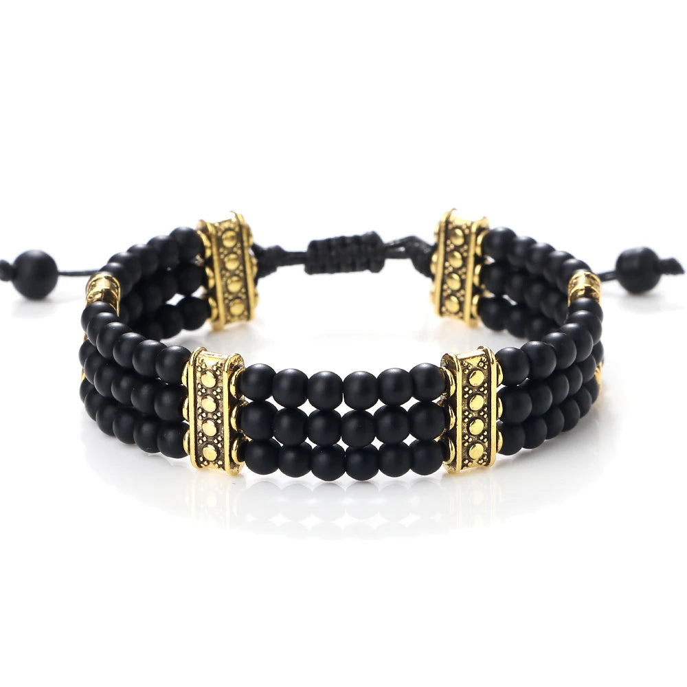 Black beaded bracelet with gold accents on a white background