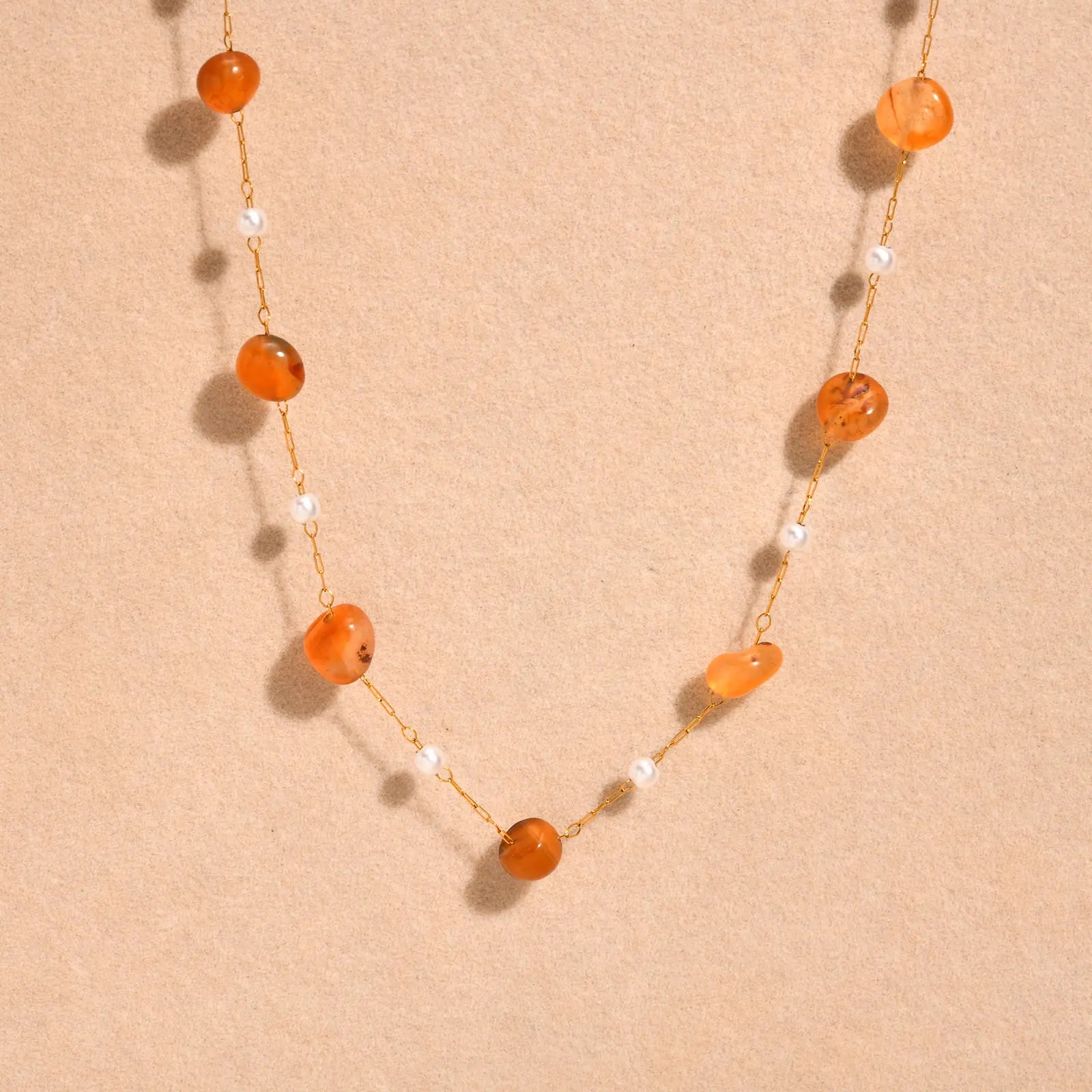 Necklace with orange beads on a beige background
