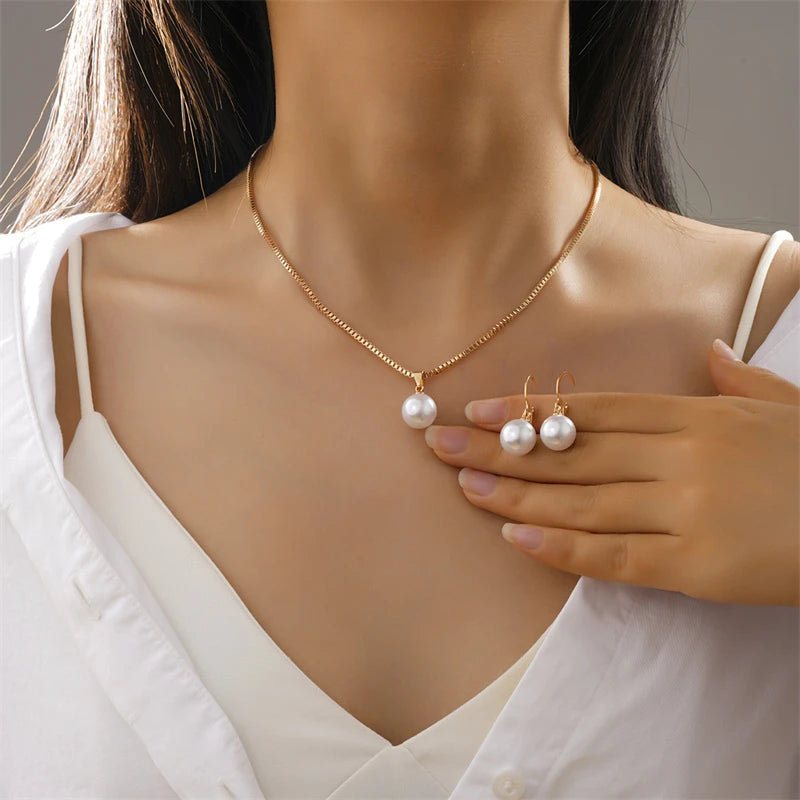 Pearl necklace and earrings on a model with a neutral background