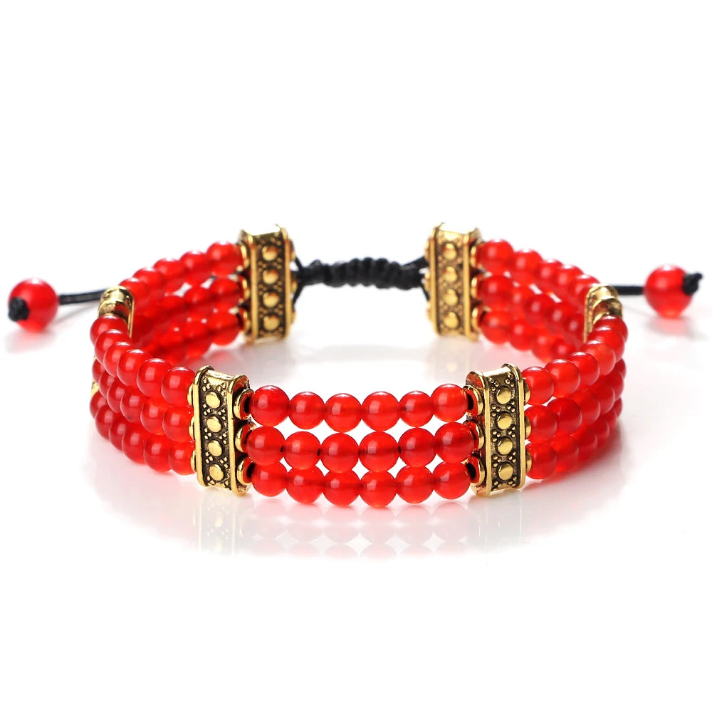 Red beaded bracelet with gold accents on a white background