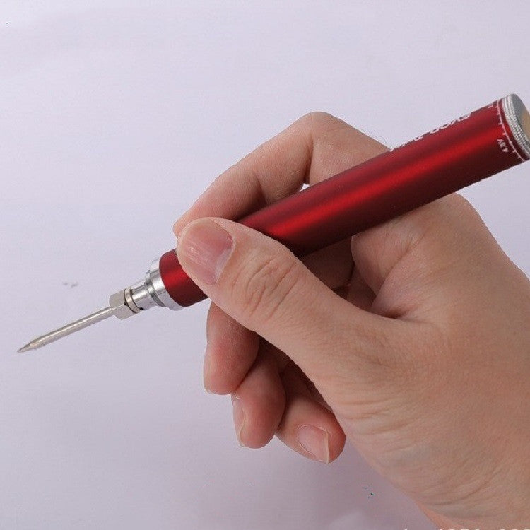Hand holding a red precision soldering iron pen with a fine tip, shown against a plain light background.