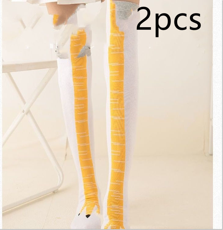 Model standing indoors wearing novelty white knee-high socks with yellow bird-leg design and grey feather-like tops; black 