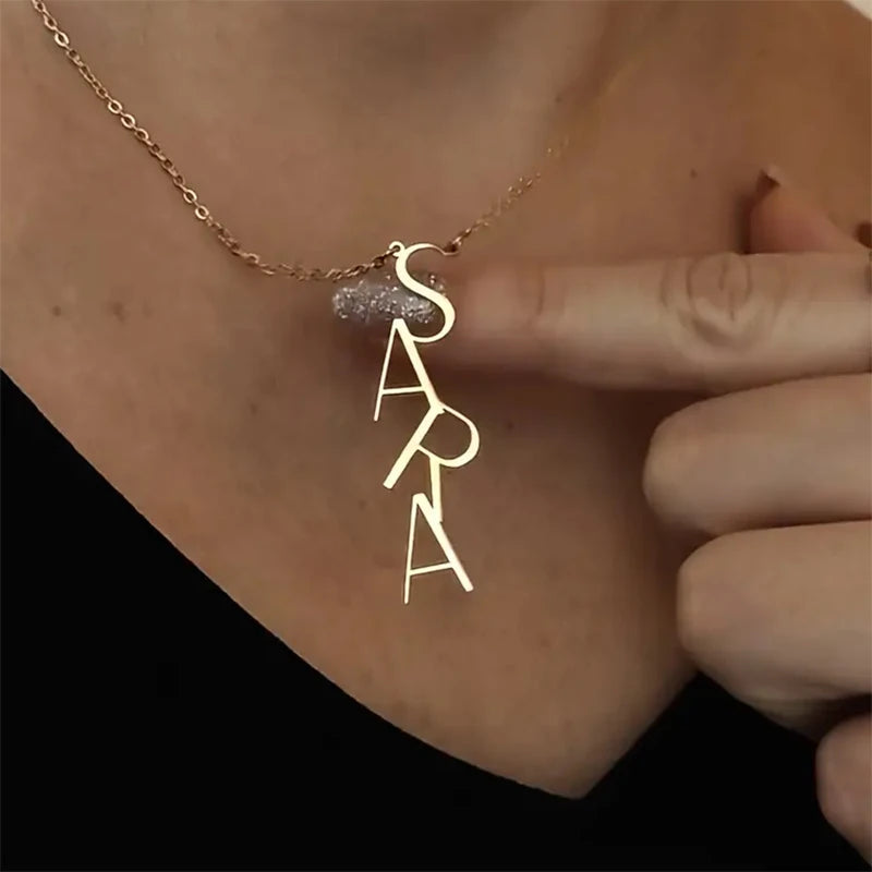 Gold necklace with 'SARA' pendant on a person's neck