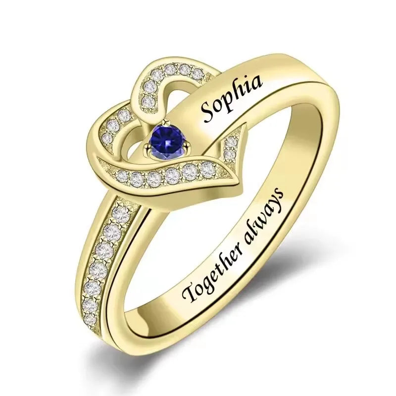 Gold ring with a blue gemstone and 'Sofia' engraved, on a white background