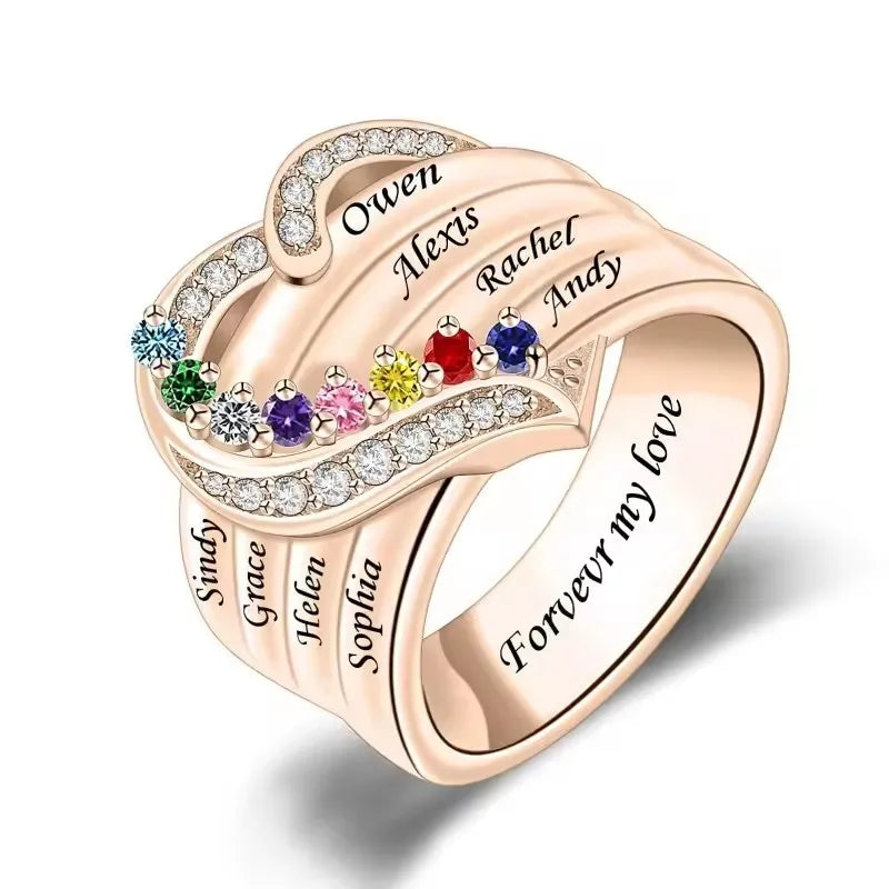 Rose gold ring with names and colored gemstones on a white background