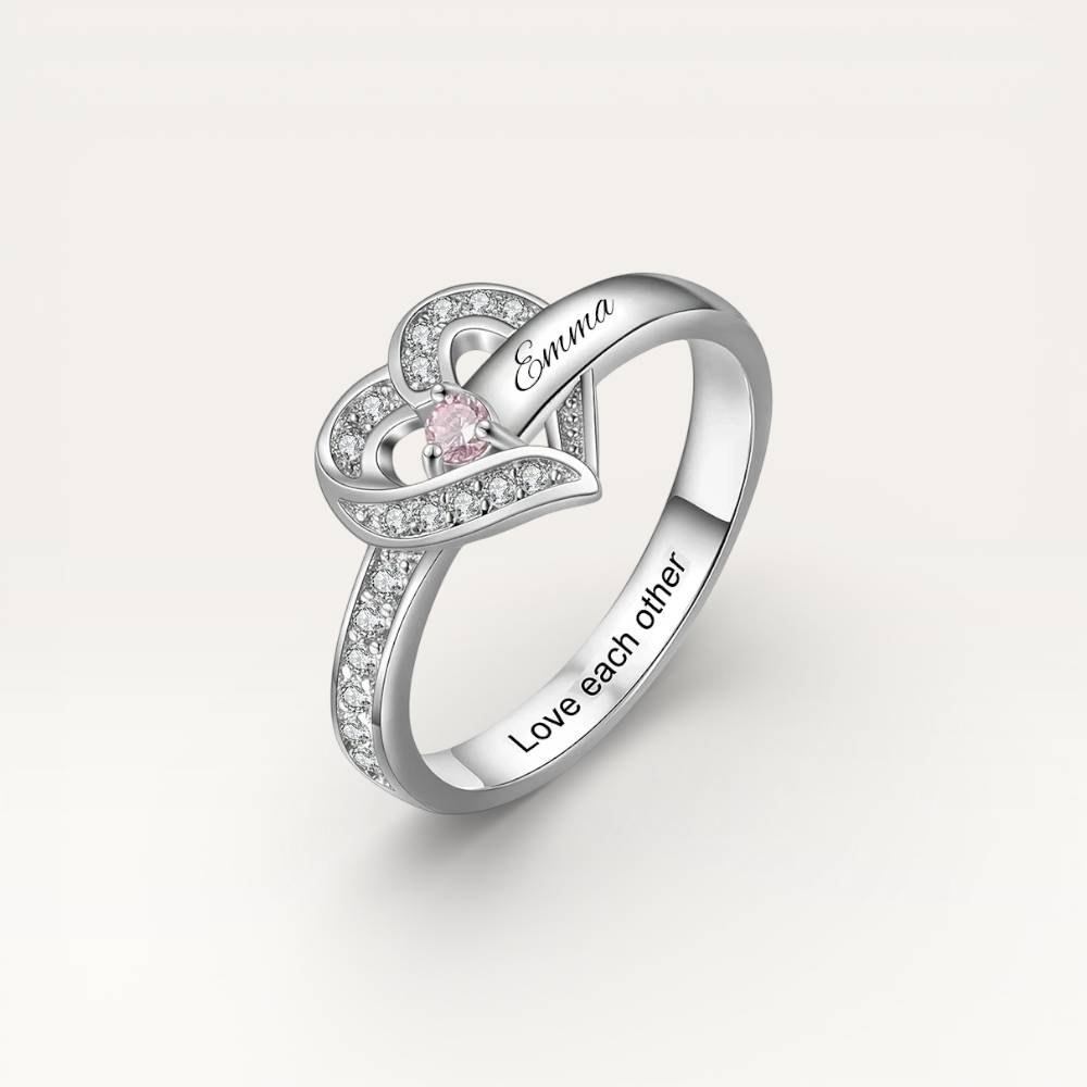 Silver ring with pink gemstone and 'Emma' engraving on a light gray background