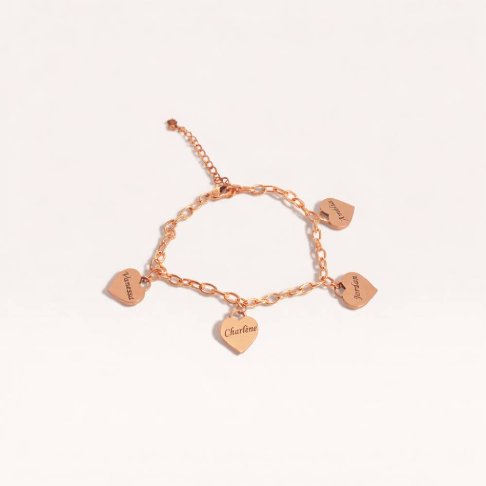 Rose gold bracelet with heart-shaped charms on a light pink background