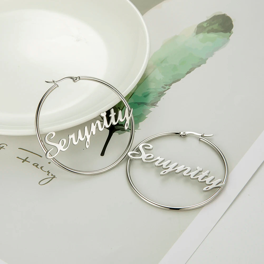 Silver hoop earrings with 'Serenity' text on a light background